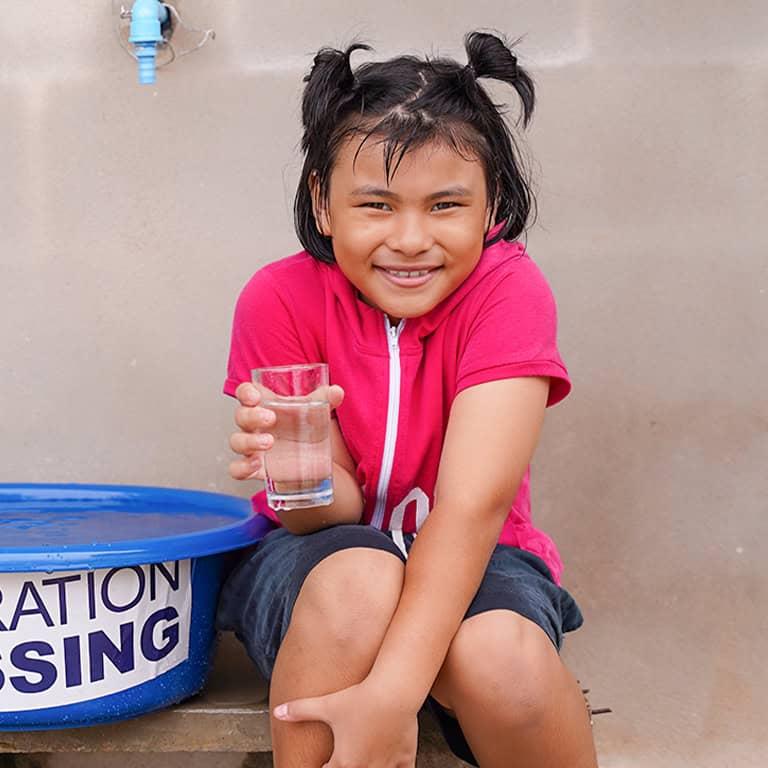 Girl with water from CBN's Operation Blessing