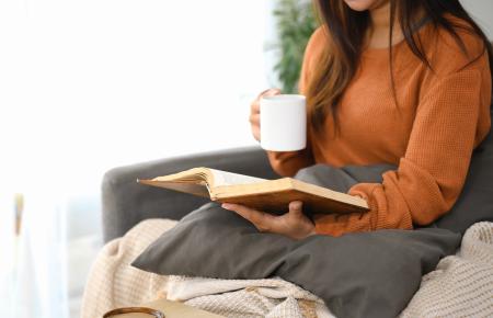 Woman reading Bible and drinking coffee
