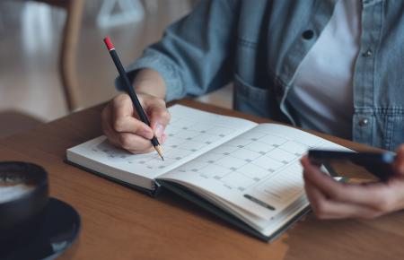 person looking at a calendar and phone