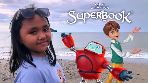 Christy stands on the beach in Indonesia and looks back at the viewer. Chris and Gizmo from Superbook stand behind her to the right and gesture excitedly at the CBN Animation and Superbook logos above them.