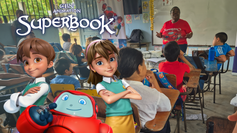 Children in Honduras gather in a classroom to learn about Jesus through Superbook. Chris, Joy, and Gizmo stand in the foreground on the left and smile. The CBN Animation and Superbook logos are stacked above them.